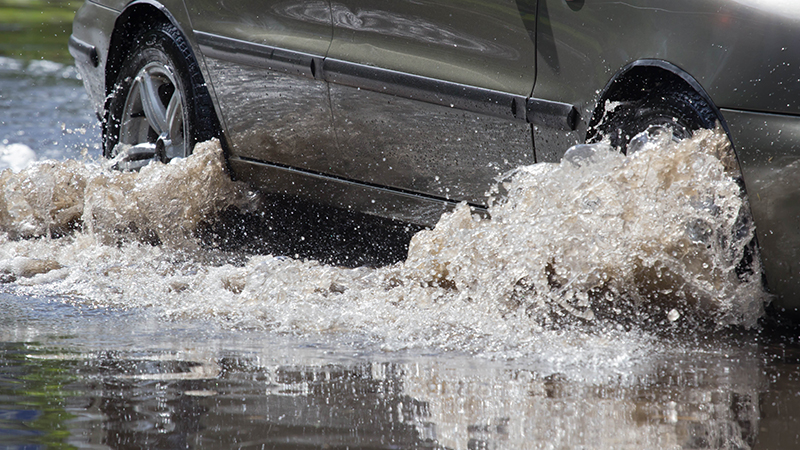 大雨造成的洪水泛滥，汽车在洪水泛滥的道路上行驶
